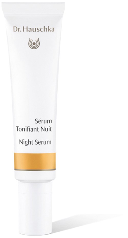 A white tube labeled 'Night Serum' by Dr. Hauschka, with gold accent, standing upright on a white background.