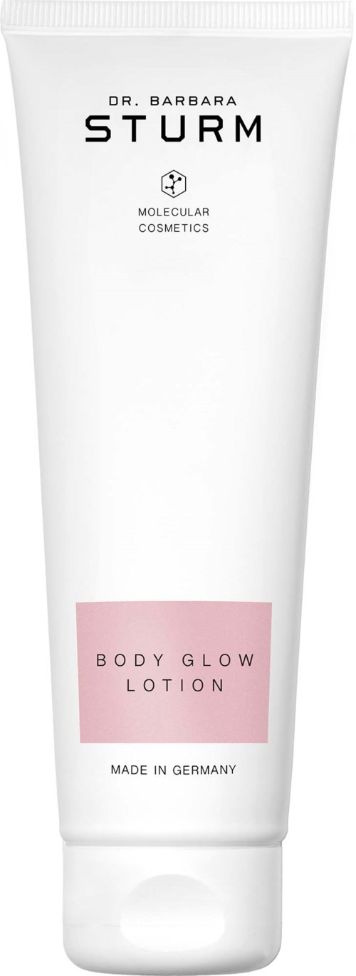 En hvit tube med Dr. Barbara Sturm Body Glow Lotion med rosa etikett og svart tekst, laget i Tyskland.