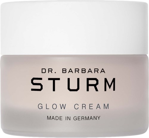 A white jar labeled Dr. Barbara Sturm Glow Cream, made in Germany, with black and purple text.