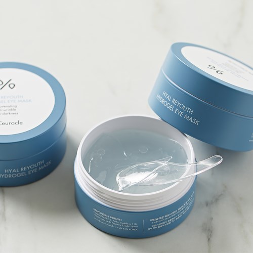 Open blauwe potten met heldere gel en oogmasker, op een lichte ondergrond.