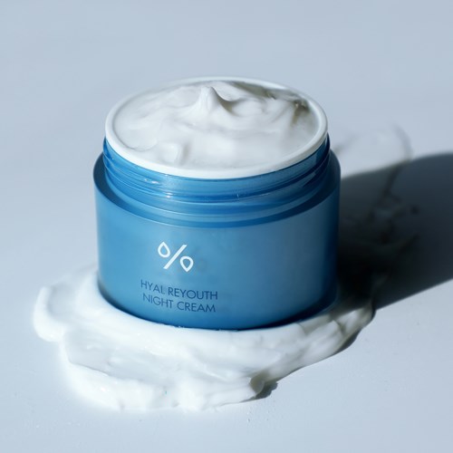Blauwe pot met Hyal Reyouth nachtcrème met uitgesmeerde crème ernaast. Eenvoudig, strak ontwerp.