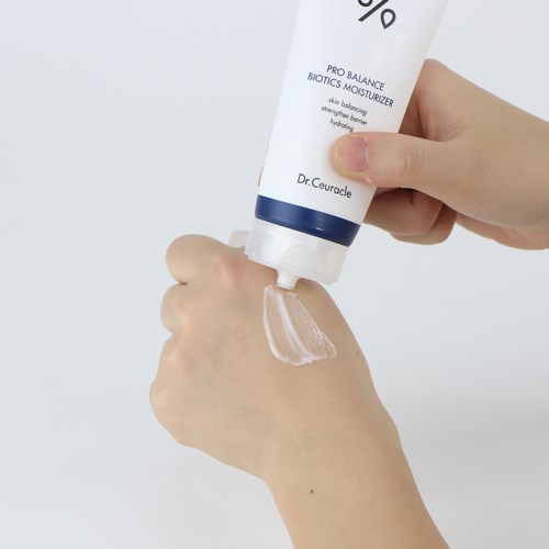 Iemand brengt vochtinbrengende crème aan uit een witte tube op de hand.