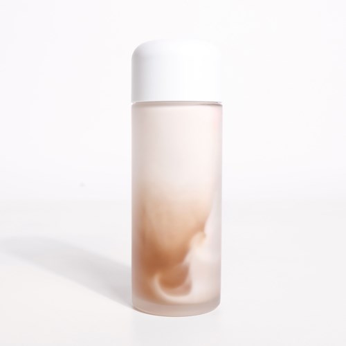 A tall, white and beige cylindrical bottle with a rounded cap. It looks like a skincare or cosmetic product.