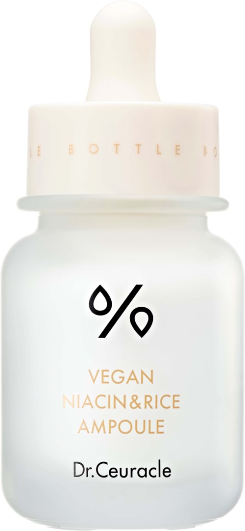 Een witte druppelfles met label 'Vegan Niacin & Rice Ampoule' door Dr. Ceuracle, eenvoudig ontwerp met zwarte en oranje tekst.