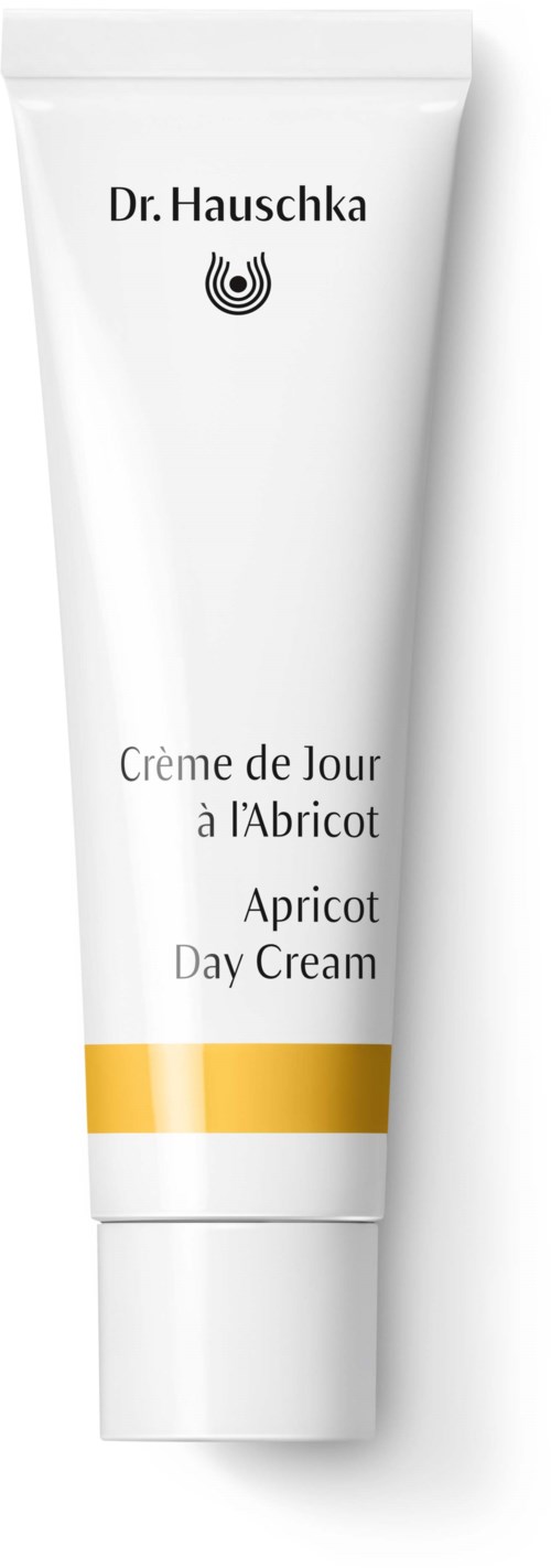 Ein weißer Tuben Aprikosen-Tagcreme mit gelbem Streifen, genannt Dr. Hauschka, in mehreren Sprachen geschrieben.