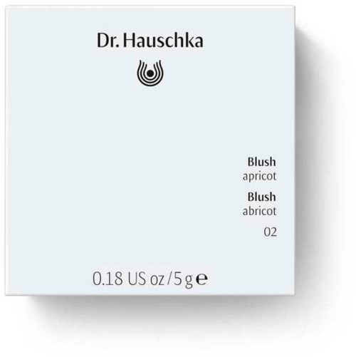 Kauneustuotteiden pakkaus Dr. Hauschka -logolla, aprikoosin sävyjä, vaaleassa pakkauksessa.