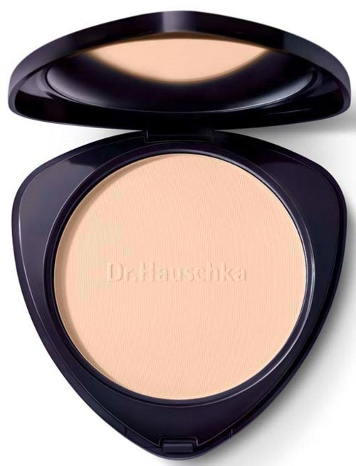 A compact with light-colored pressed powder, featuring the brand name 'DrHauschka' embossed in the center.