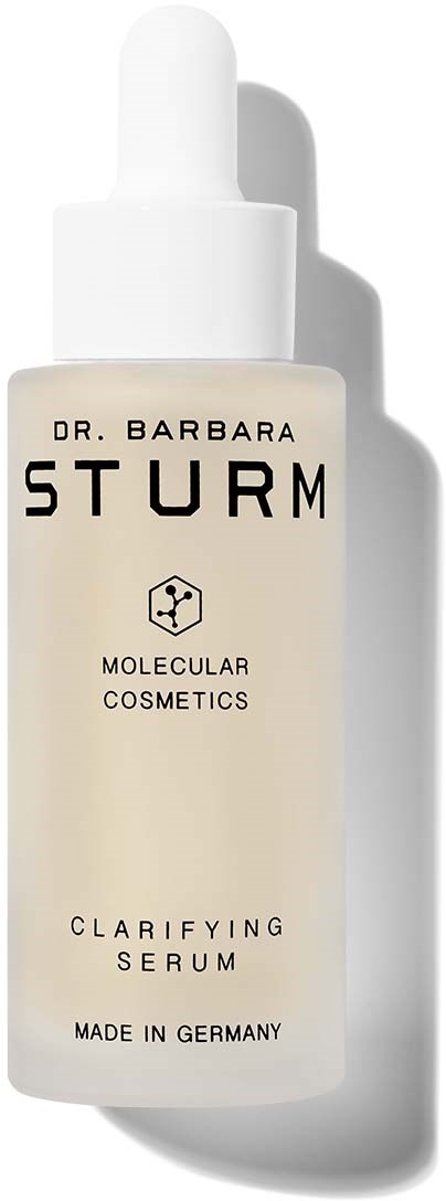 Eine weiße Pipettflasche mit der Aufschrift Dr. Barbara Sturm Clarifying Serum, hergestellt in Deutschland, mit molekularer Kosmetikthematik.