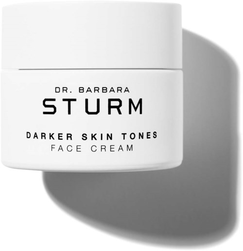 Ein weißer Behälter mit der Aufschrift 'Dr. Barbara Sturm Darker Skin Tones Face Cream' und einem Schatten auf der rechten Seite.