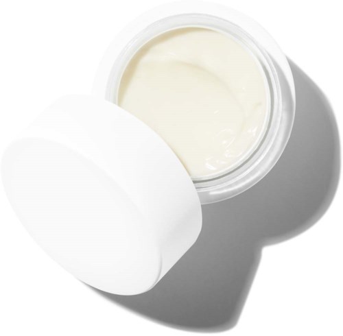 Ein weißer Behälter mit Creme, offen mit Deckel daneben auf weißem Hintergrund.