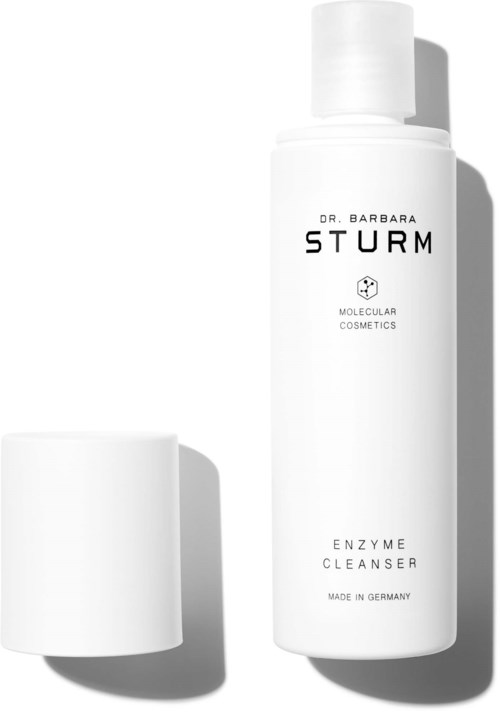 Eine weiße Flasche mit der Aufschrift 'Dr. Barbara Sturm Enzyme Cleanser' und einem Deckel daneben.