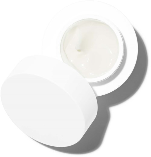 Ein kleiner runder Behälter mit weißer Creme und Deckel daneben auf einer weißen Oberfläche.