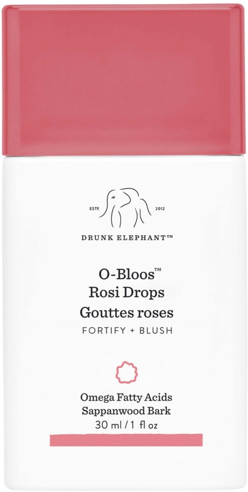 En hvit flaske med rosa hette, viser en logo, produktnavn og ingredienser som omegafett og rosedrops.