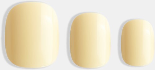 Three artificial nails of different sizes are displayed, all painted in a light cream color.