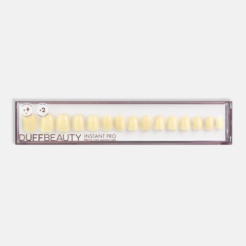 A box contains yellow press-on nails arranged in a straight line, labeled DUFFBEAUTY INSTANT PRO.