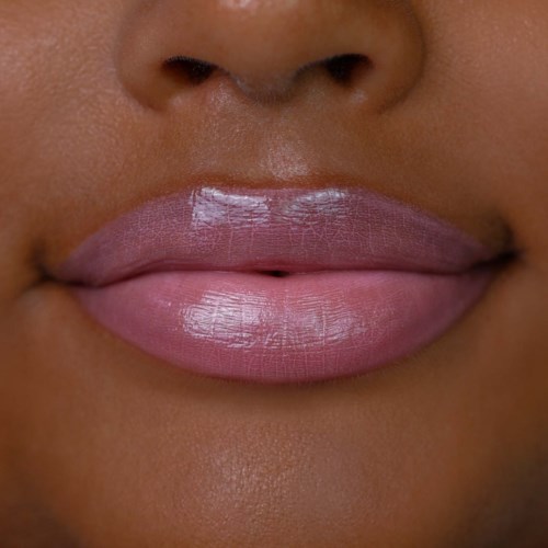 Close-up of lips with glossy pink lipstick, showing part of the nose and skin.