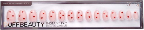 A set of artificial nails with red hearts on a white background, in a clear box for nail decoration.