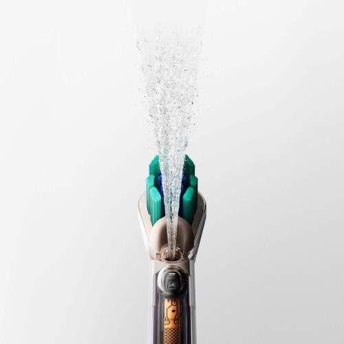 A close-up of an electric shaver with water flowing from the top.