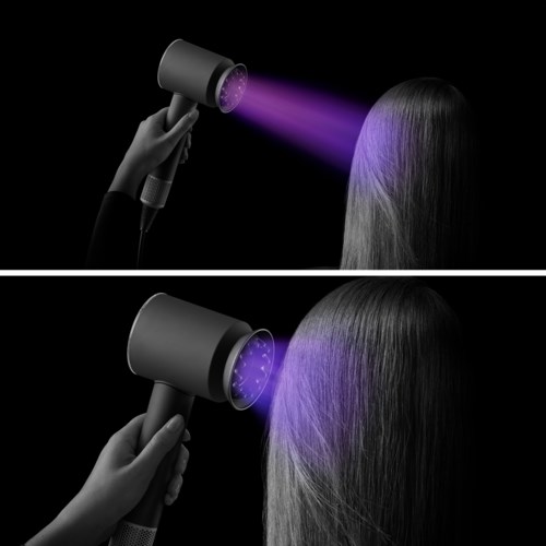 Eine Person nutzt einen speziellen Haartrockner mit violettem Licht, um Haare zu trocknen oder zu behandeln. Der Hintergrund ist schwarz.