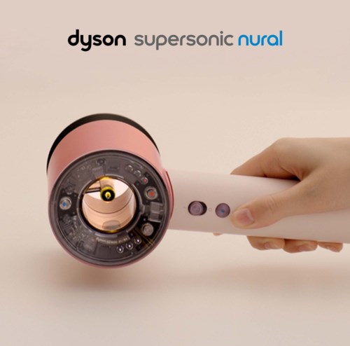 A pink Dyson vacuum cleaner with a white handle, shown from the front, with brand names above it.