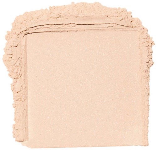 En beige puder omger en rektangulär fast del, troligen makeup, med slät yta och oregelbundna kanter.