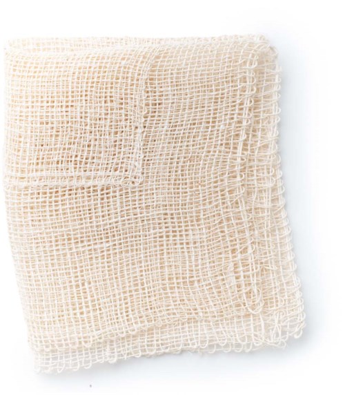 A beige, open-weave net cloth, folded neatly with a pocket, on a white surface.