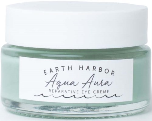 A small jar of Earth Harbor Aqua Aura reparative eye crème with a white lid and light green cream inside.