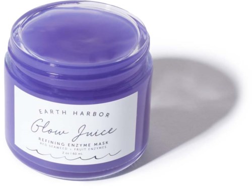 En lila burk av Earth Harbor Glow Juice-rengöringsenzymmaska med vit etikett, kastar skugga.
