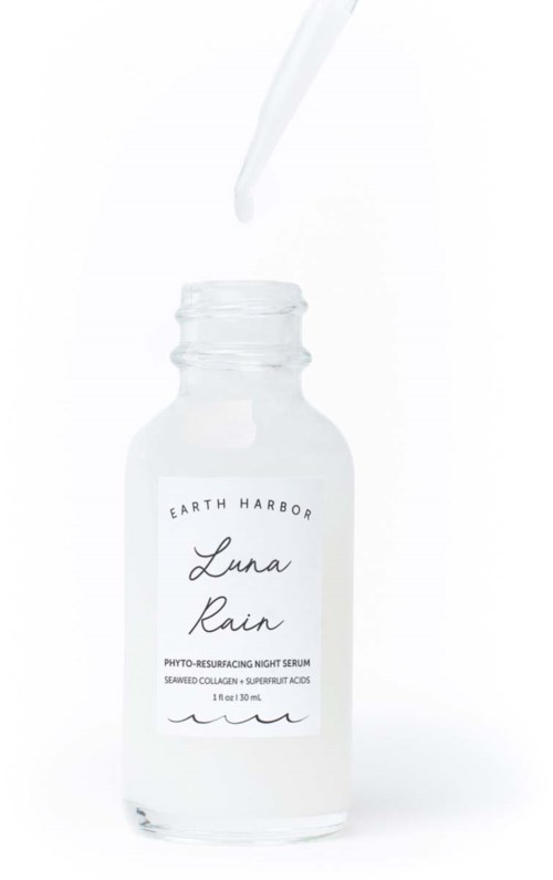 Klein flesje met pipet, met heldere vloeistof, gelabeld 'Luna Rain' nachtserum. Eenvoudig en strak ontwerp.