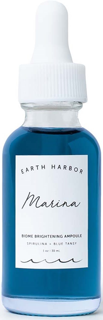 A small glass bottle with a white dropper cap, containing blue liquid, labeled 'Earth Harbor Marina' skincare product.
