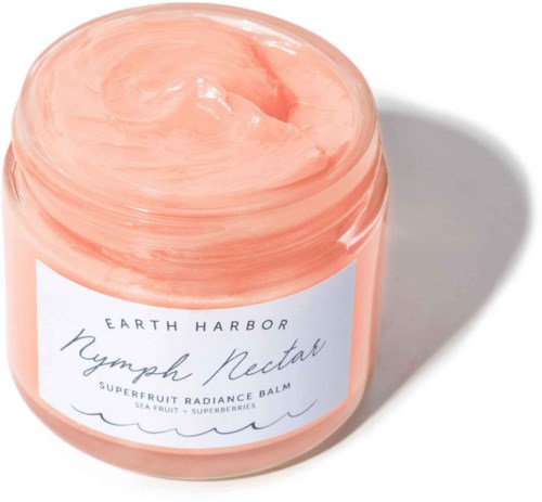 A peach-colored jar of Earth Harbor Nymph Nectar balm with sea fruit and superberries for radiance.