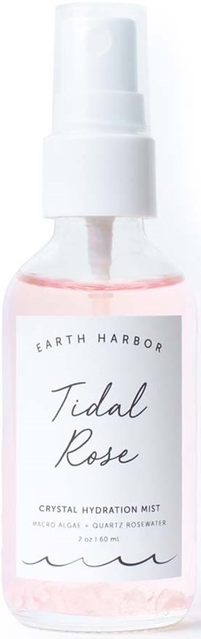 A small transparent bottle with a white spray cap, labeled 'Tidal Rose' by Earth Harbor, contains a pink liquid.