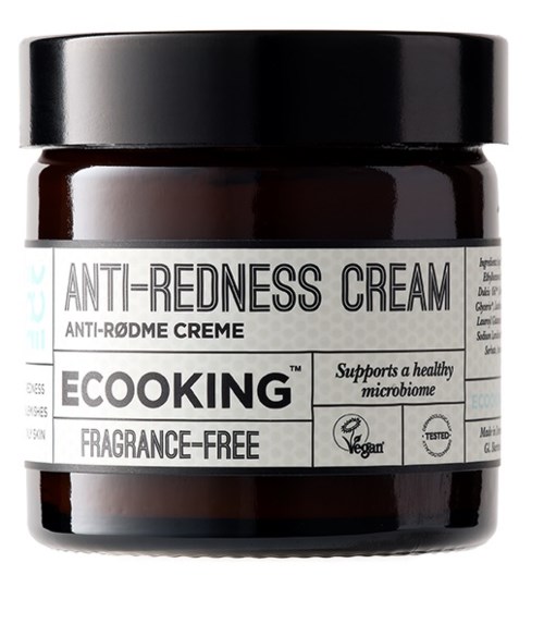 A jar of anti-redness cream with a black lid, labeled as fragrance-free and supporting healthy skin.
