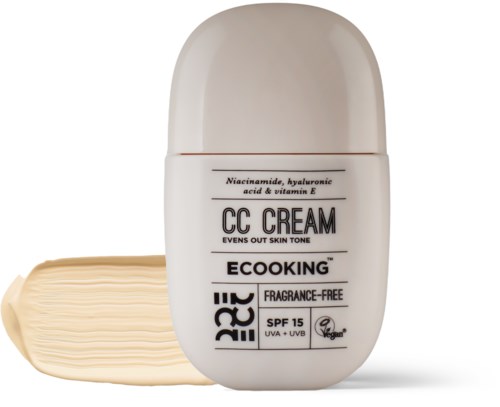 A white bottle of CC cream with a small amount spread on a surface, labeled as SPF 15 and fragrance-free.