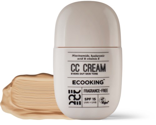 A white bottle of CC cream with a beige swatch beside it, labeled as eco-friendly, SPF 15, and fragrance-free.