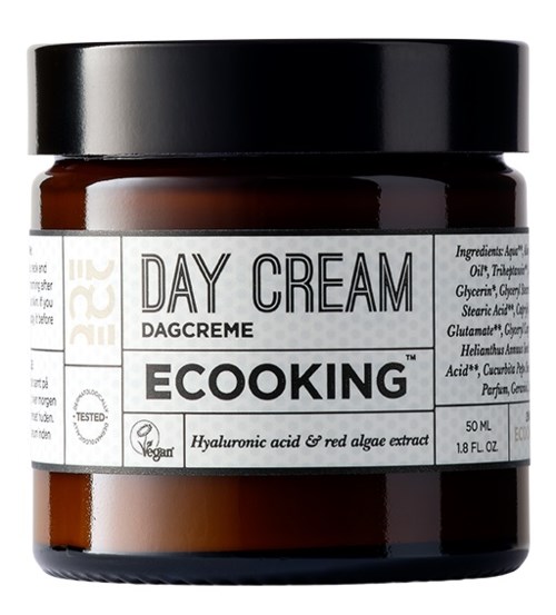 En brun burk med svart lock märkt "Day Cream", innehåller hyaluronsyra och red algae-extrakt.
