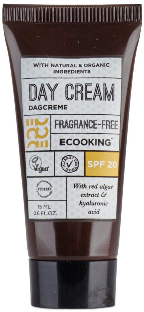 En brun tub med dagkräm med SPF 20, naturliga ingredienser, vegansymbol och vatten- och oljekmärken.