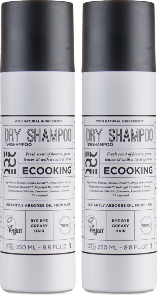 Two bottles of dry shampoo with black and white labels, mentioning natural ingredients and vegan certification.
