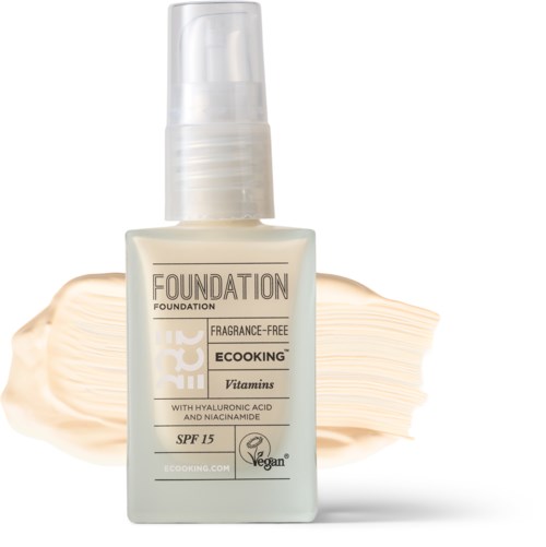 A bottle of foundation with a pump, labeled 'Vegan', 'Fragrance-Free', SPF 15, and containing vitamins.