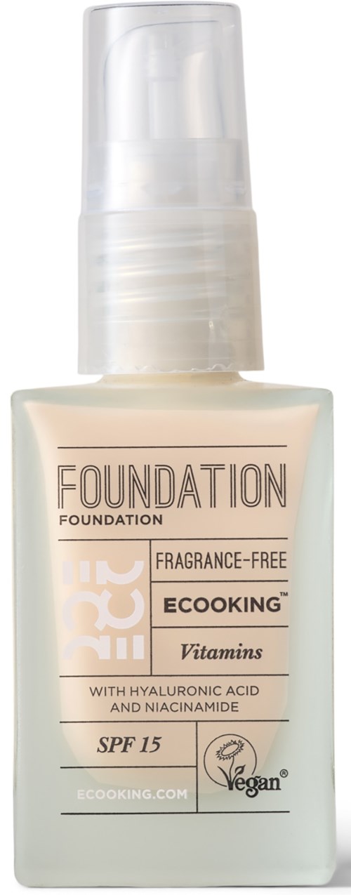 A bottle of foundation makeup labeled as fragrance-free, vegan, with SPF 15, containing vitamins, hyaluronic acid, and niacinamide.