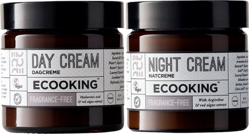 Two brown jars of skincare cream, labeled for day and night use, fragrance-free, with algae extract.