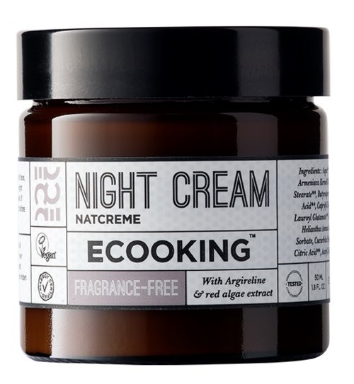Ein dunkelbrauner Nachtcreme-Topf mit schwarzem Deckel und weißem Etikett mit Marken- und Produktinformationen.