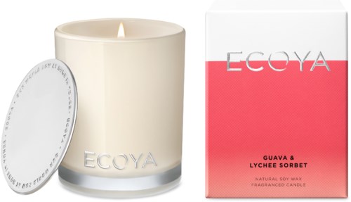 Een crèmekleurige kaars met EcoYa-merk en een rood-wit doosje, duiden op de geur guave en lychee.
