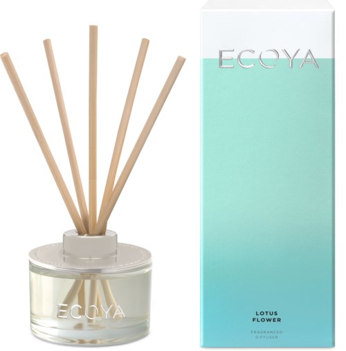 Een aromadiffuser met houten stokjes in een glazen pot, naast een lichtblauwe verpakking met 'ECOYA LOTUS FLOWER'.