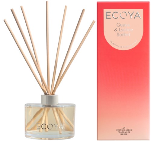 Een geurverspreider met stokjes en een roze en witte doos met label ecoya guava en lychee sorbet.