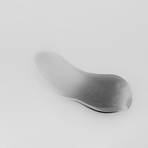 Ein klares, gebogenes, gelartiges Objekt auf einem schlichten Hintergrund, möglicherweise eine Seife oder ein kleines Glasteil.