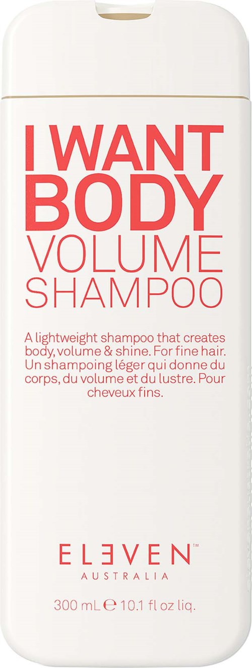 Eine weiße Flasche mit roten und rosa Texten, die I WANT BODY VOLUME SHAMPOO von ELEVEN, Australien, bewerben.