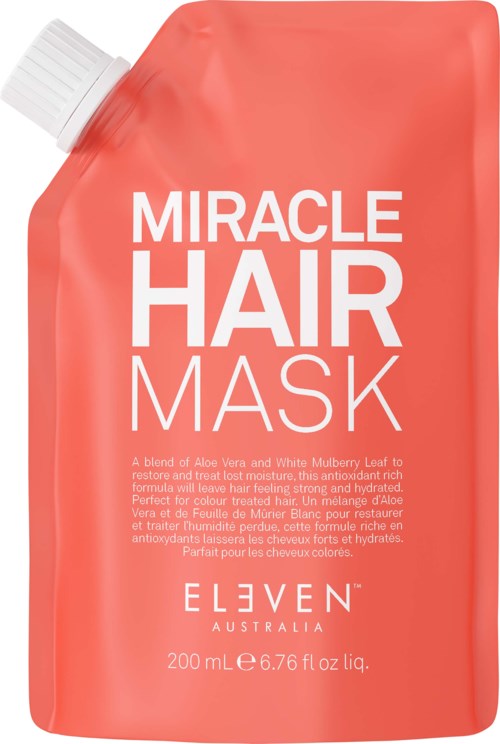 A coral-colored hair mask pouch with white and pink text, featuring product name and description.