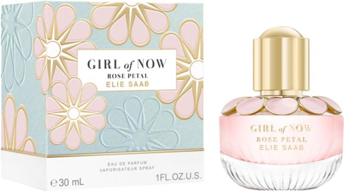 A perfume bottle with pink liquid and flower-shaped designs on the cap, next to a floral-themed box.