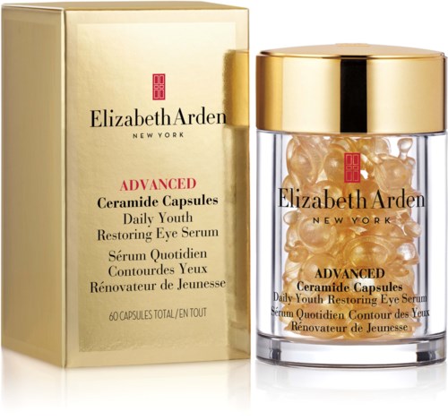A gold and clear jar with capsules, beside a gold box, all for Elizabeth Arden eye serum.